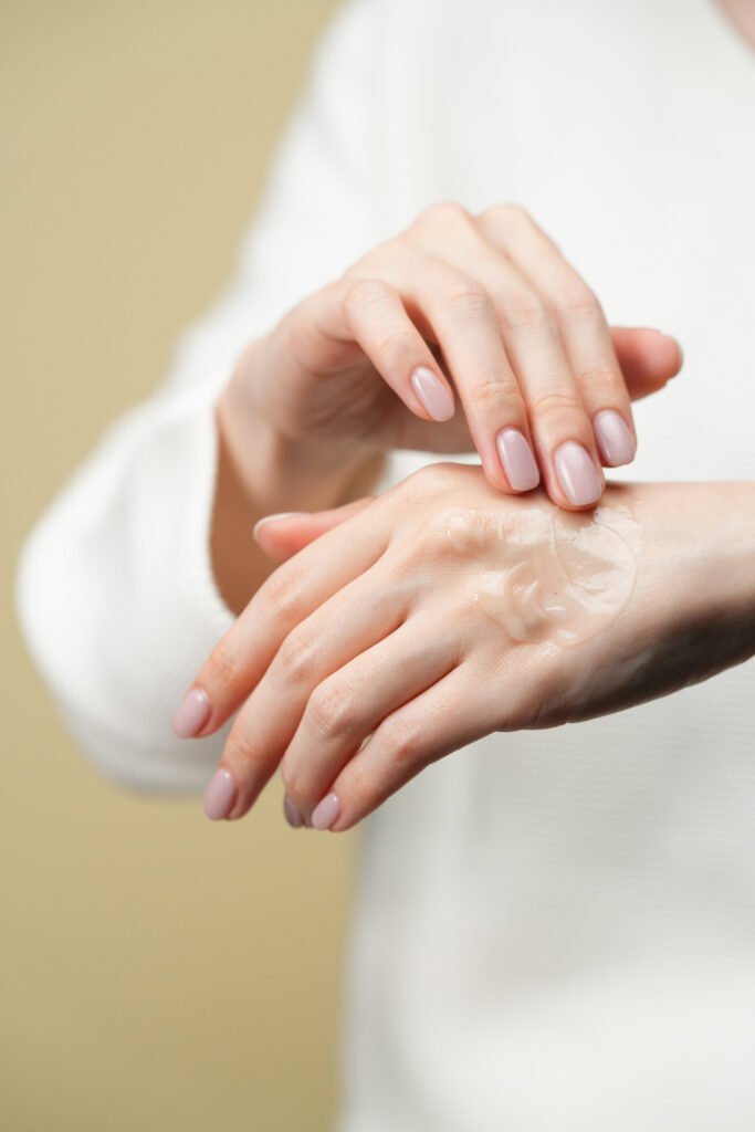 Hands applying skincare gel to a cheek before treatment