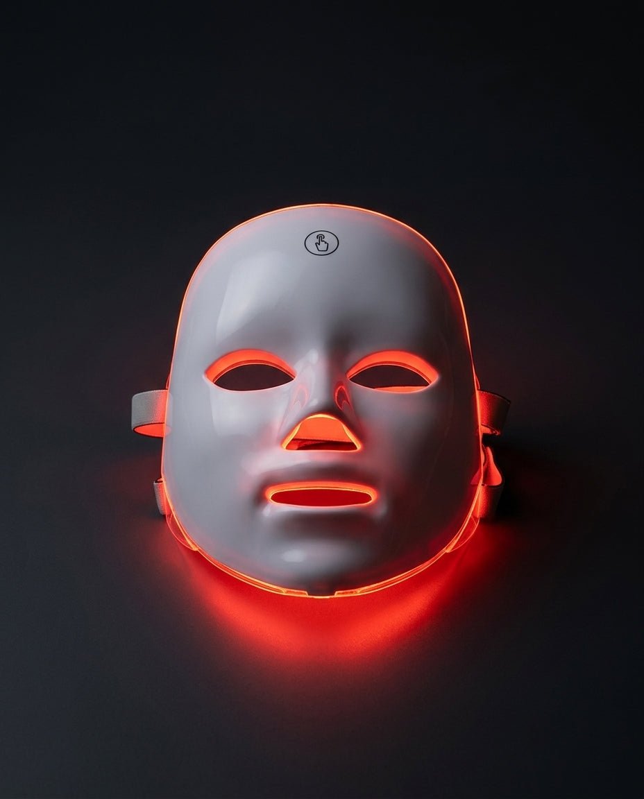 White LED face mask glowing red on a dark background